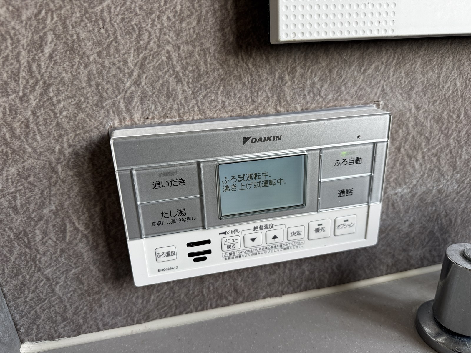 浴室の壁に取り付けた新しいエコキュートのリモコン